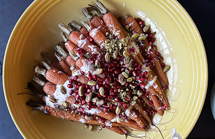 Des carottes cuites au four, sauce au sésame décoré avec quelques grains de grenade et pistaches.