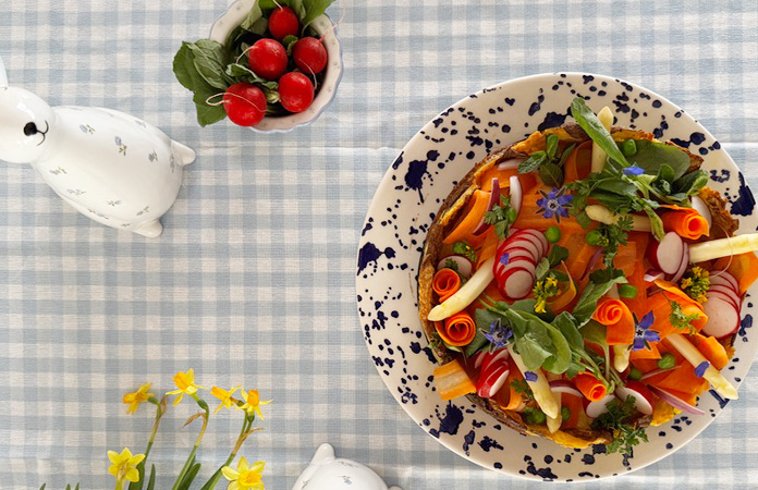 Décoration printanière de quiche avec radis, asperges, fleurs comestibles et herbes fraîches