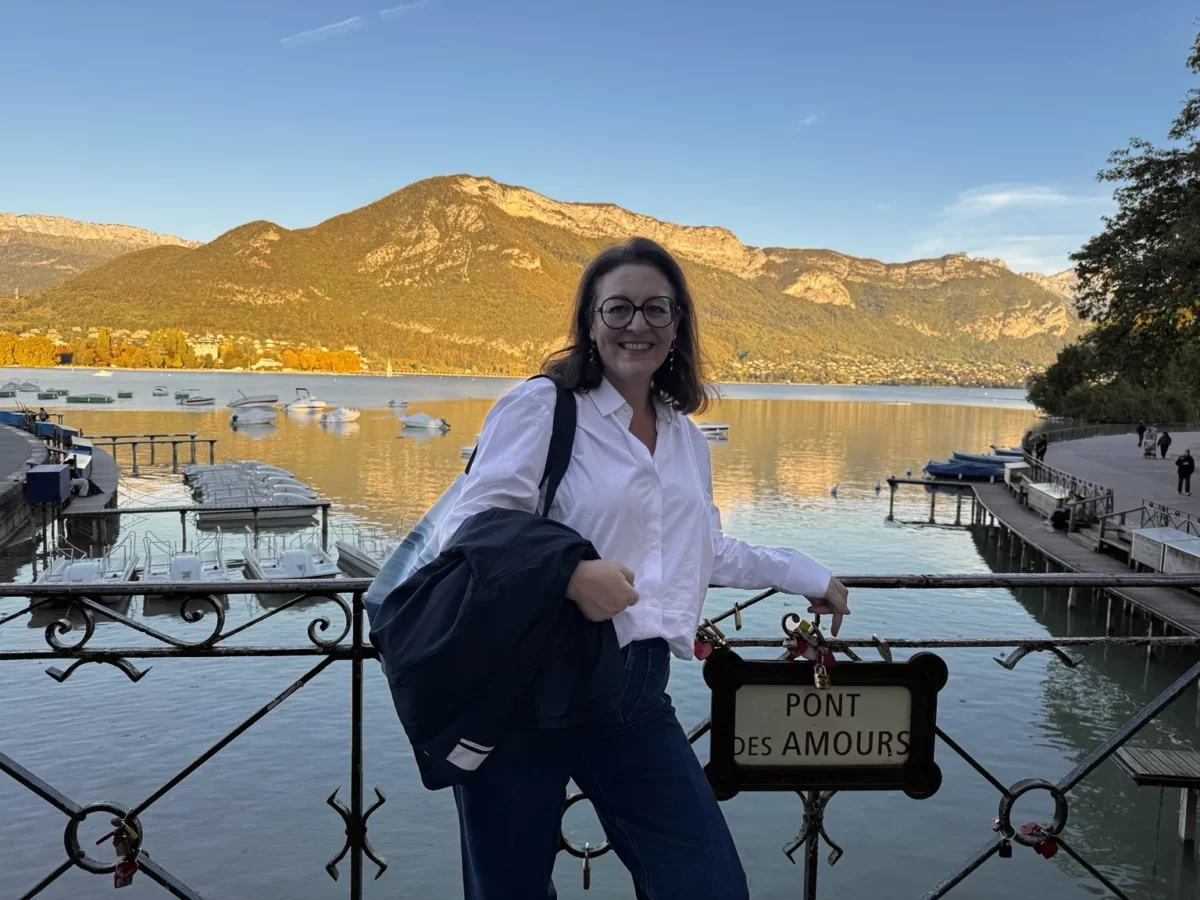 ALT : Le Pont des Amours à Annecy avec le lac et les montagnes e arrière-plan.